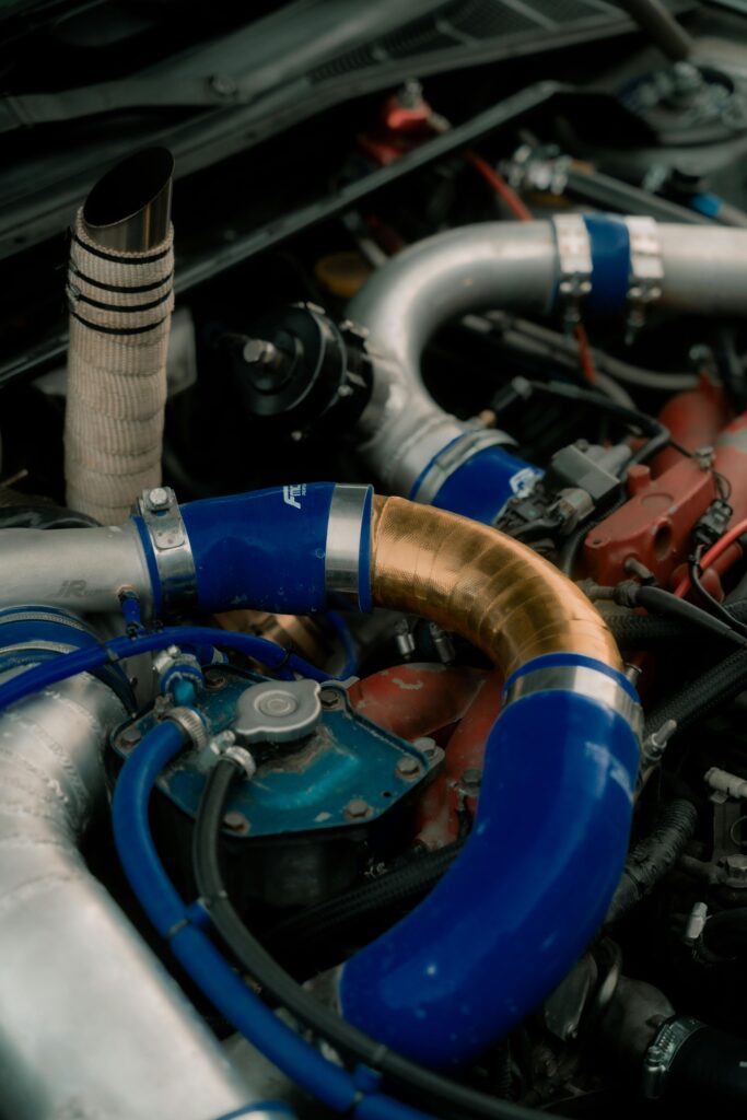 Detailed view of a car engine showing blue and metallic pipes in Cremona, Italy.